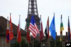 La bandera de Estados Unidos, en el centro, ondea durante una ceremonia en la sede de la UNESCO el martes 25 de julio de 2023 en París.