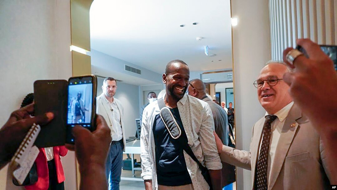 FILE - Sylvain Itte, French Ambassador to Niger, greets French journalist Olivier Dubois, center, at the airport in Niamey, Niger, March 20, 2023. Itte left Niger on Wednesday, about a month after the military government ordered his expulsion.