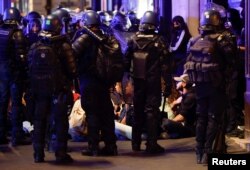 Police officers stand guard as people protest near Opera Garnier, following the death of Nahel, a 17-year-old teenager killed by a French police officer in Nanterre during a traffic stop, and against police violence, in Paris, France, June 30, 2023.