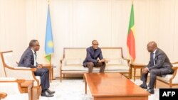 Rwandan President Paul Kagame, center, gestures towards Beninese Foreign Minister Aurelien Agbenonci upon his arrival at Cotonou Cadjehoun Airport on April 15, 2023. 