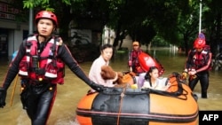 Rescue workers evacuate residents with an inflatable boat on a flooded street after storms in Guilin, in southwestern China's Guangxi province, June 19, 2024.