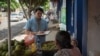 Mientras reportaba en Masaya, Nicaragua, el periodista Wilfredo Miranda conversa con una vendedora de frutas. [Cortesía]