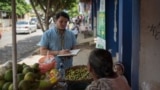 Mientras reportaba en Masaya, Nicaragua, el periodista Wilfredo Miranda conversa con una vendedora de frutas. [Cortesía]