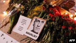 Plakat, potret, bunga, dan lilin di Place du Trocadero di Paris, 17 Februari 2024 untuk menghormati Alexey Navalny yang meninggal di penjara Arktik, Rusia. (Geoffroy VAN DER HASSELT / AFP)