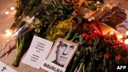 This photograph taken on Feb. 17, 2024, shows portrait placards, flowers and candles displayed as a tribute in Paris to Alexey Navalny after the announcement that the Kremlin's critic had died in an Arctic prison. China described Navalny's death as 'Russia's internal affair.'