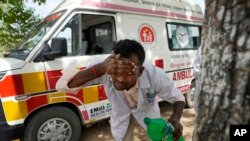 Jitendra Kumar, a paramedic who travels in ambulance, washes his face with water to cool himself off after dropping a patient at Lalitpur district hospital, in Banpur, in Indian state of Uttar Pradesh, June 17, 2023.
