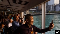 Mainland Chinese tourists ride the Star Ferry in Hong Kong, April 12, 2023. 