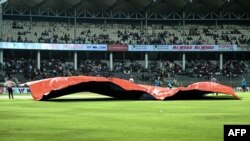 সিলেটের সিলেট আন্তর্জাতিক ক্রিকেট স্টেডিয়ামে বাংলাদেশ ও আয়ারল্যান্ডের মধ্যে দ্বিতীয় একদিনের আন্তর্জাতিক (ওডিআই) ক্রিকেট খেলা চলাকালীন বৃষ্টির কারণে ম্যাচটি স্থগিত হওয়ার পর মাঠের কর্মীরা পিচ ঢেকে দিচ্ছেন। (ছবি মুনিরের) উজ জামান/এএফপি)