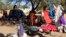FILE - Families displaced in Muhajiriya, sit at Zamzam IDP camp in North Darfur.