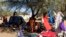 FILE - Families displaced by the recent fighting in Muhajiriya, sit at Zamzam camp in North Darfur February 5, 2009.