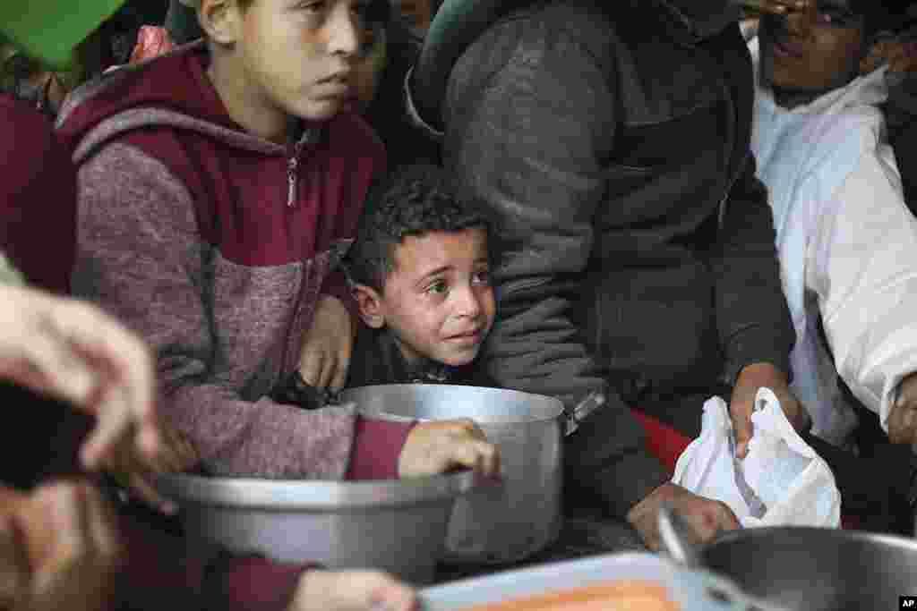 Palestinians line up for free food distribution during the ongoing Israeli air and ground offensive in Khan Younis, Gaza Strip.