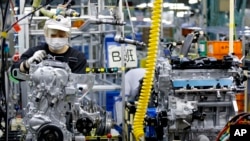 Seorang pekerja tengah memeriksa mesin di lini produksi di pabrik Nissan Motor Co. di Yokohama, Jepang, pada 2 Agustus 2017. (Foto: AP/Shizuo Kambayashi)