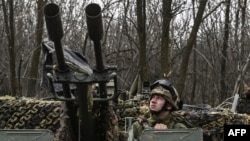 A Ukrainian serviceman scans the sky from an anti-air gun near Bakhmut, on March 24, 2023.