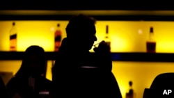 ARCHIVO - En esta fotografía del 30 de noviembre de 2017, un cliente toma su bebida mientras come en un bar en Nueva Jersey. 