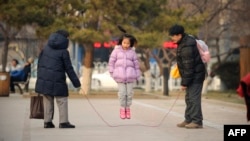 FILE — A girl plays with her family in Beijing, Dec. 7, 2012. During its 35 years, China's one-child policy fostered a culture of families doting on their only offspring. After the Chinese government ended the policy in 2016, it started encouraging couples to have more children.