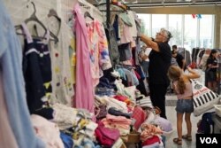 Una voluntaria pone en perchas la ropa donada para distribuir a los necesitados.