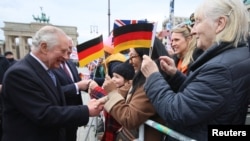 Britain's King Charles greets people as he visits Berlin, March 29, 2023. 