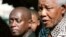 FILE - Former South African president Nelson Mandela, right, meets with playwright Mbongeni Ngema at Mandela's home in Johannesburg, June 17, 2002. 