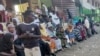 FILE - People from states of Khartoum and al-Jazira, displaced by the ongoing conflict in Sudan between the army and paramilitaries, wait to receive aid from a charity organisation in Gedaref on Dec. 30, 2023. 