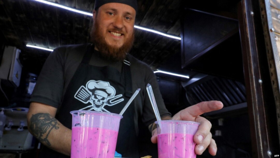 A cook serves Saltibarsciai soup during the Pink Soup Fest in Vilnius, June 10, 2023. Saltibarsciai is a traditional Lithuanian cold beet soup usually served in summer and usually made with buttermilk, sour cream, hard-cooked eggs, cucumbers, and dill.