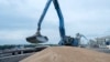 FILE - An excavator loads grain into a cargo ship at a grain port in Izmail, Ukraine, April 26, 2023.