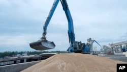 FILE - An excavator loads grain into a cargo ship at a grain port in Izmail, Ukraine, April 26, 2023.