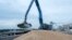 FILE - An excavator loads grain into a cargo ship at a grain port in Izmail, Ukraine, April 26, 2023.