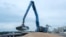 FILE - An excavator loads grain into a cargo ship at a grain port in Izmail, Ukraine, on April 26, 2023.