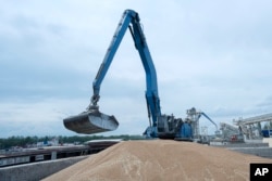 FILE - An excavator loads grain into a cargo ship at a grain port in Izmail, Ukraine, on April 26, 2023.