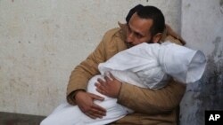 A Palestinian holds his child, killed in the Israeli bombardment of the Gaza Strip, at a morgue in Rafah, Feb. 21, 2024.