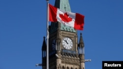 资料照片: 2017年3月22日加拿大安大略省渥太华国会山和平塔前飘扬着的加拿大国旗