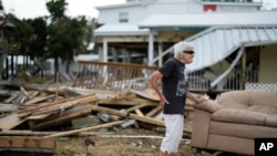 FILE - Tina Brotherton, 88, looks over the remains of her business, Tina's Dockside Inn, which was completely destroyed in Hurricane Idalia, as was Brotherton's nearby home, in Horseshoe Beach, Florida, Sept. 1, 2023. 