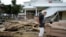 FILE - Tina Brotherton, 88, looks over the remains of her business, Tina's Dockside Inn, which was completely destroyed in Hurricane Idalia, as was Brotherton's nearby home, in Horseshoe Beach, Florida, Sept. 1, 2023. 