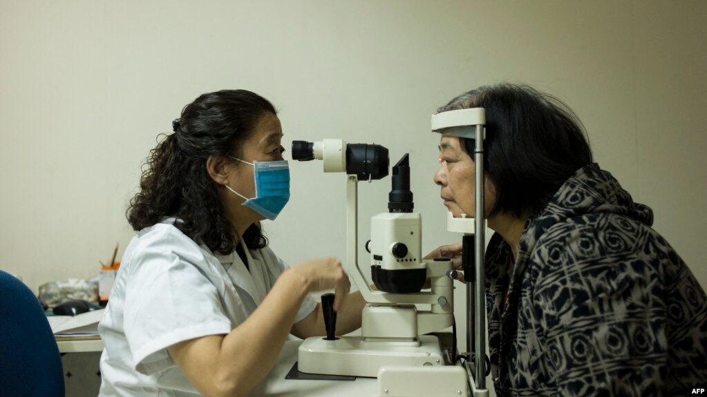 资料照：北京同仁医院的一名眼科医生为病人检查眼睛。（2014年10月8日）(photo:VOA)