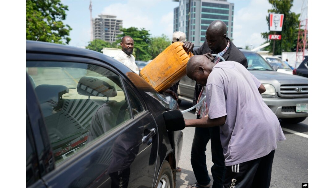 FILE - A man buys black market fuel in Lagos, Nigeria, May 30, 2023. President Bola Tinubu has scrapped a decadeslong government-funded subsidy, leading to long lines at fuel stations as drivers scrambled to stock up before costs rise.