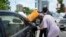 A man buys black market fuel opposite a petrol station in Lagos, Nigeria, Tuesday, May 30, 2023. The end of a government-funded subsidy that reduce the price of gasoline has cut overall use, and also cut the black market's reselling subsidized fuel.