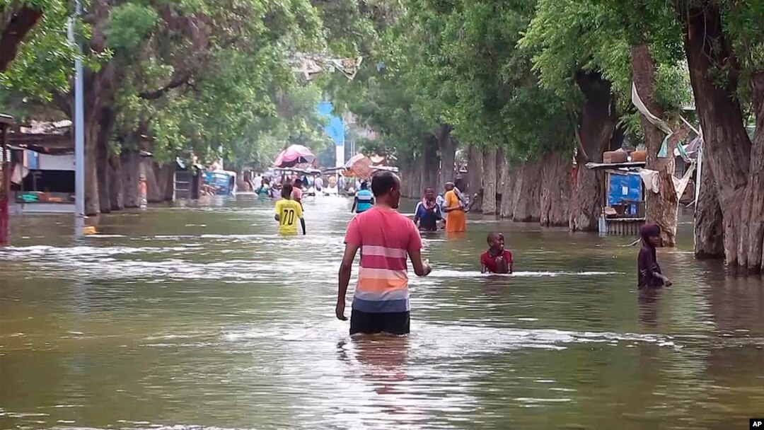 In this image from video, residents move through floodwaters in the town of Beledweyne, Somalia, Nov. 19, 2023. 