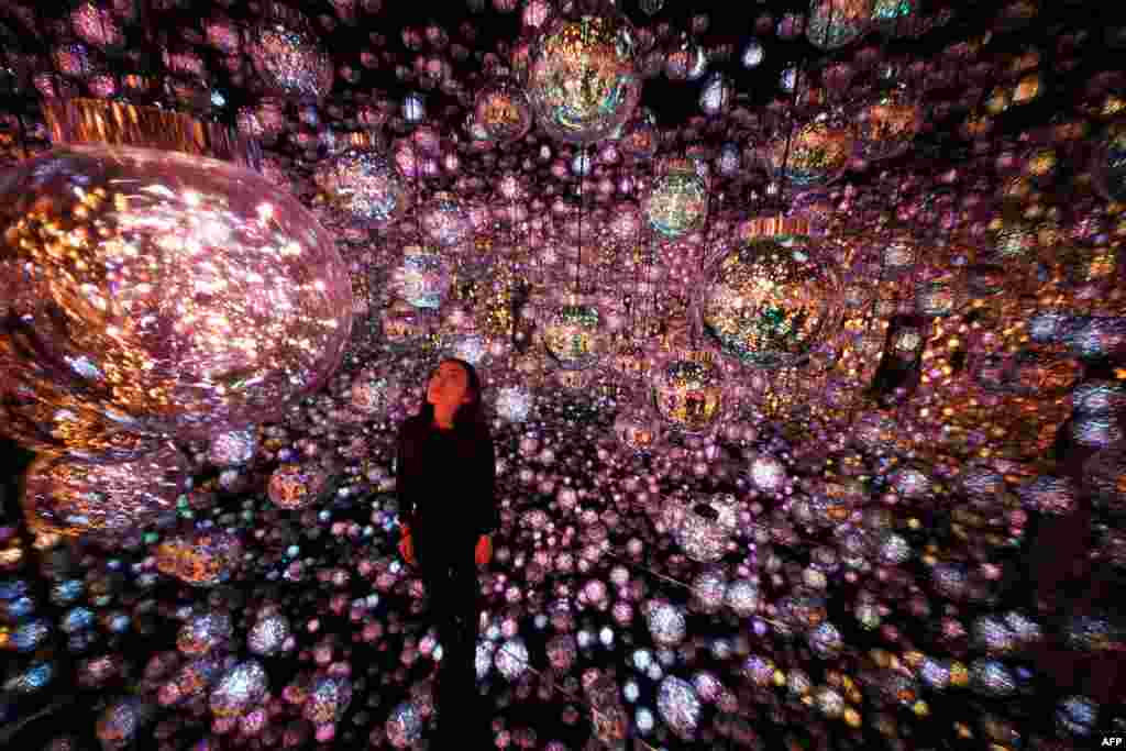 Seorang staf berdiri di depan karya seni interaktif &quot;Bubble Universe&quot; selama pratinjau media teamLab Borderless: MORI Building Digital Art Museum di Azabudai Hills, Tokyo, Jepang.