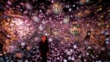 A staff member stands at the interactive artwork "Bubble Universe" during a media preview of the teamLab Borderless: MORI Building Digital Art Museum at Azabudai Hills in Tokyo, Japan, Nov, 22, 2023.
