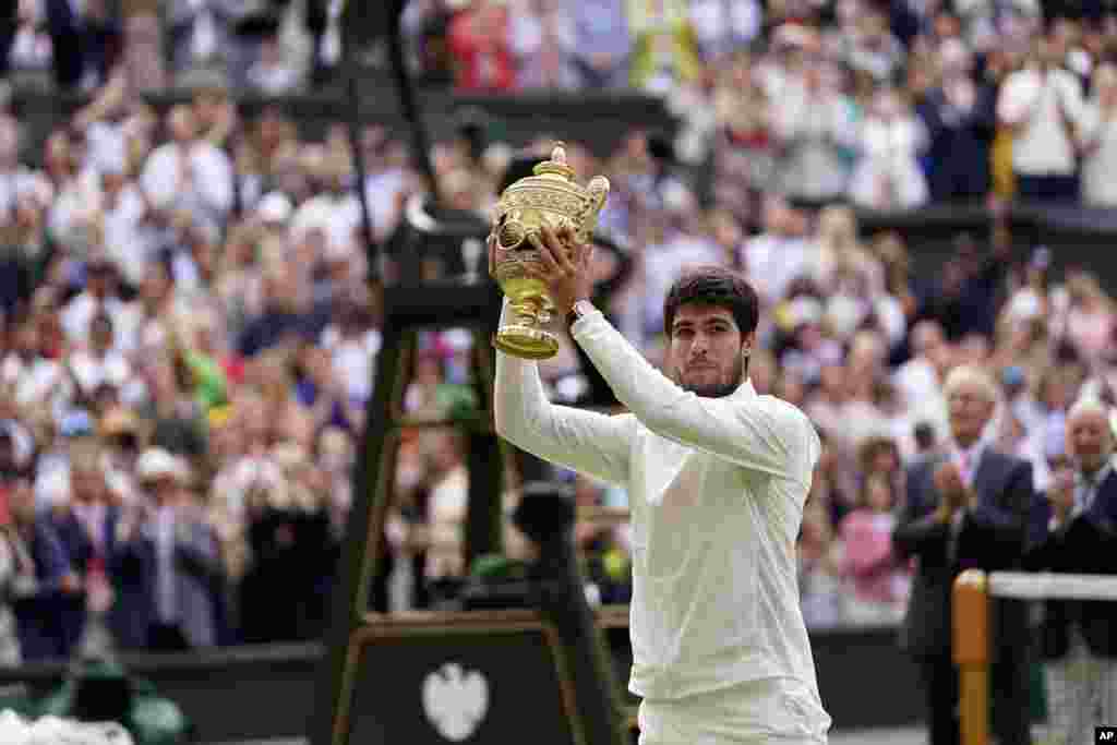 Spain's Carlos Alcaraz celebrates with his trophy after beating Serbia's Novak Djokovic in the men's singles final on day fourteen of the Wimbledon tennis championships in London, July 16, 2023. 