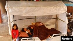 Seorang pasien dirawat di sebuah tempat perawatan di tempat terbuka di luar Rumah Sakit Nasser di tengah konflik antara Israel dan Hamas, di Khan Younis di Jalur Gaza, 14 November 2023. (Foto: Ibraheem Abu Mustafa/Reuters)