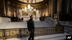 FILE - Jason Nioka, a former judo champion and deacon who's in charge of the largest contingent of Olympic chaplains, about 40 priests, nuns and lay Catholics, walks inside the Madeleine church, May 30, 2024 in Paris. 