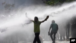 Police fire water cannons to disperse supporters of Sri Lanka main opposition during a protest rally against high taxes and increases in electricity and fuel charges, in Colombo.