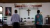 FILE - Father Dominic Maximilian Ofori, a Ghanaian Catholic priest and lecturer, stands with a LGBTQ believer at the altar of a Catholic church, in Accra, Ghana, January 18, 2024. 