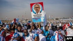 Des partisans du Front patriotique rwandais (FPR) dansent sur des chansons à la gloire du président sortant et candidat Paul Kagame, lors d'un rassemblement de campagne à Kigali, le 13 juillet 2024.