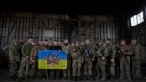 乌克兰总统泽连斯基（中）前往俄乌正在激战的巴赫穆特附近的一处阵地与乌军士兵举着军旗合影。（2023年3月22日）