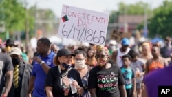 FILE - People march during a Juneteenth event on June 19, 2020, in Milwaukee. Juneteenth marks the day in 1865 when federal troops arrived in Galveston, Texas, to ensure all enslaved people were freed. (AP Photo/Morry Gash)
