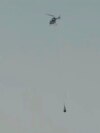 This image taken from video provided by NASA TV shows the capsule released by the Osiris-Rex spacecraft being lifted off by a helicopter after landing to Earth at Dugway Proving Ground, Utah, Sept. 24 2023. (NASA TV via AP)