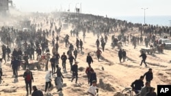 Palestinians scramble for humanitarian aid on a beachfront in Gaza City, Gaza Strip, Feb. 25, 2024.