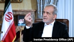 In this photo released by the Iranian Presidency Office, President Masoud Pezeshkian speaks in a live televised interview by state TV, at his office in Tehran, Aug. 31, 2024.